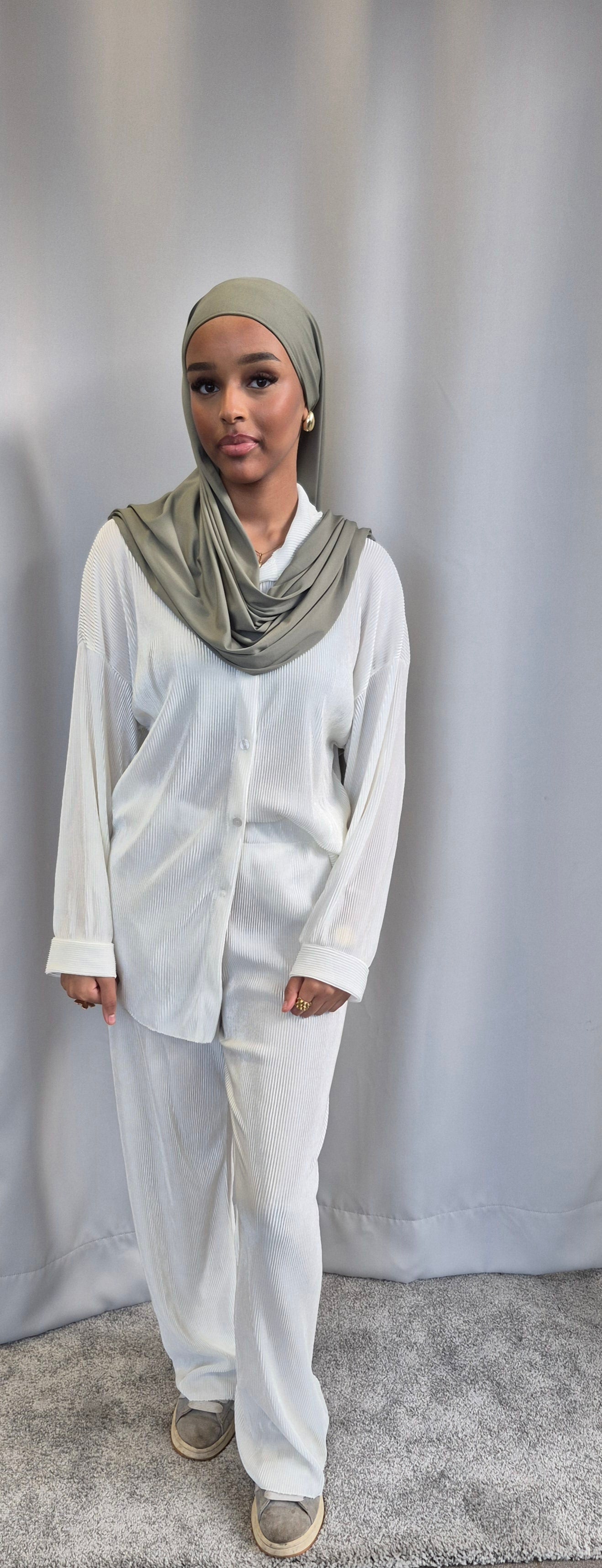 A woman stands on a gray carpet before a plain gray curtain, wearing the Bihi Boutique Shop Stylish Black Opal Co-ord Set—an oversized, fashionable one size outfit.