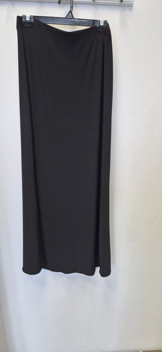 The Bihi Boutique Maxi Stretchy Skirt in size L, non-tight, hangs on a hanger against a white wall.